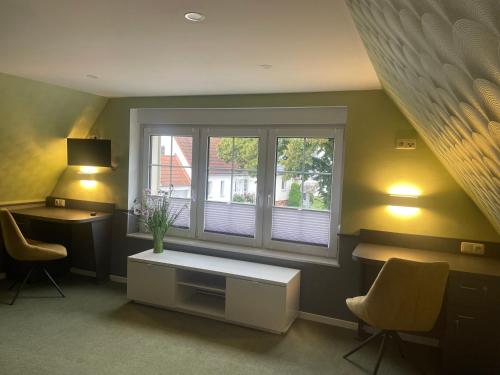a room with a desk and a window with two chairs at Heinrich Heine in Tangermünde
