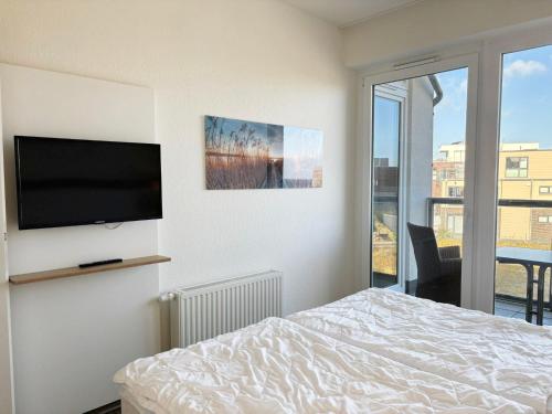 a bedroom with a bed and a flat screen tv at Ostseeblick-Bollwark Whg 9 in Olpenitz