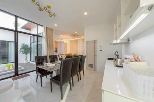a kitchen and dining room with a table and chairs at Silver Hill Pool Villa Pattaya in Na Jomtien