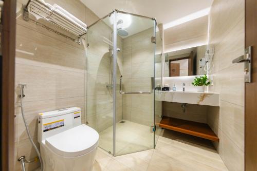 a bathroom with a toilet and a glass shower at Nesta Home - Old Street in Hanoi