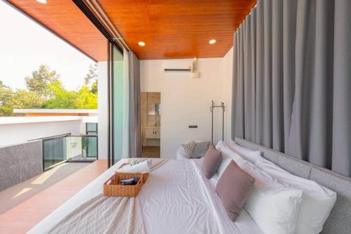 a bedroom with a large white bed on a balcony at Silver Hill Pool Villa Pattaya in Na Jomtien