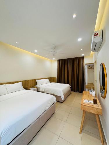 a hotel room with two beds and a table at Bayu Senja in Lahad Datu