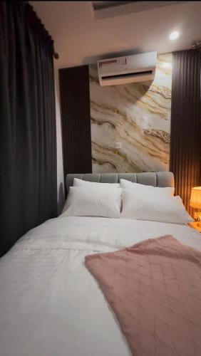 a bedroom with a white bed with a painting on the wall at Luxury Homes in Lagos