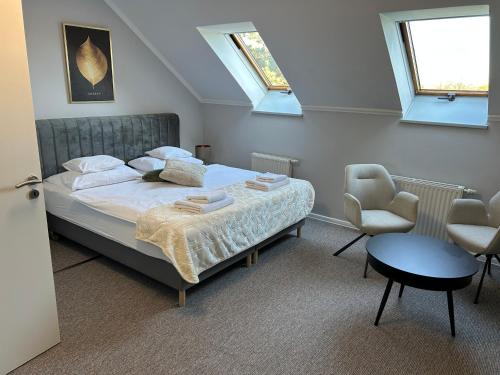 a bedroom with a bed and a table and a chair at Hotel Forras in Komárom
