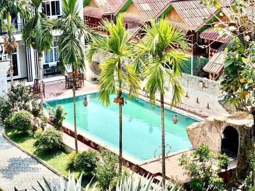 an overhead view of a swimming pool with palm trees at city mountain hotle in Vang Vieng