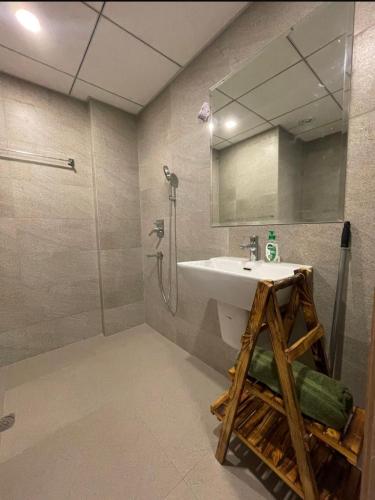 a bathroom with a sink and a shower and a mirror at Kervan stays in Greater Noida
