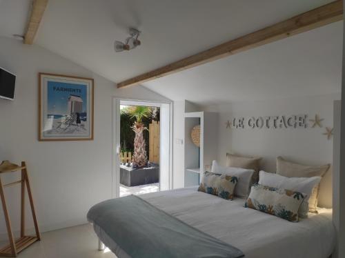 a white bedroom with a large bed with pillows at Escale et bien-être in Pornic