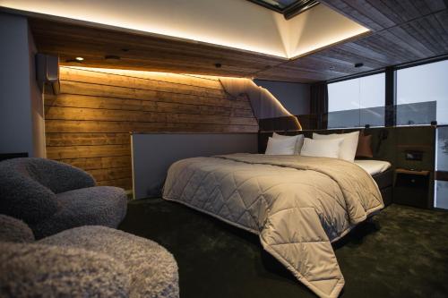 a bedroom with a large bed and a chair at Jänkä Resort in Äkäslompolo