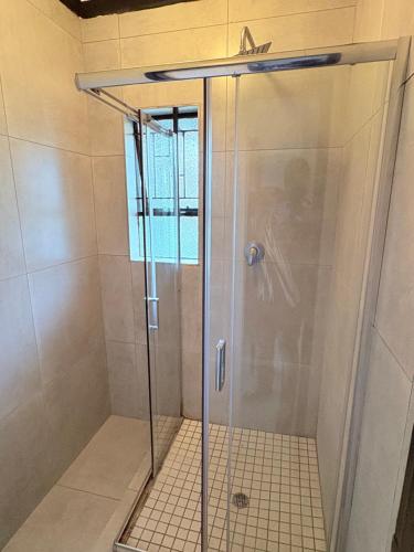 a shower with a glass door in a bathroom at 38 stay in eMalahleni