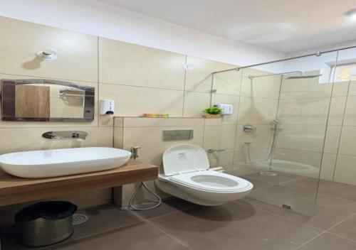 a bathroom with a toilet and a sink and a shower at SHR Resort in Rudraprayāg