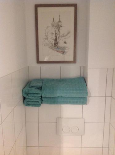 a bathroom with three towels and a picture on the wall at Apartment Kleine Kremper in Glückstadt