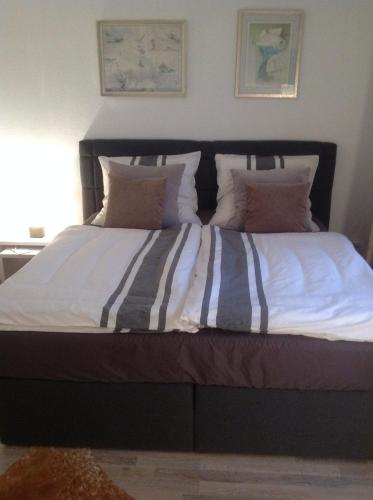 a bed with striped sheets and pillows in a bedroom at Apartment Kleine Kremper in Glückstadt