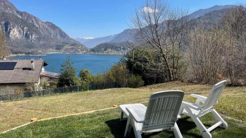 a pair of chairs sitting on a lawn with a view of a lake at Villa Carla - Lago in Mezzolago