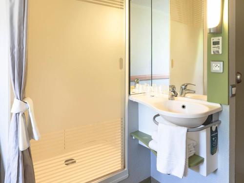 a bathroom with a sink and a mirror at ibis budget Saint Pourcain in Saint-Pourçain-sur-Sioule