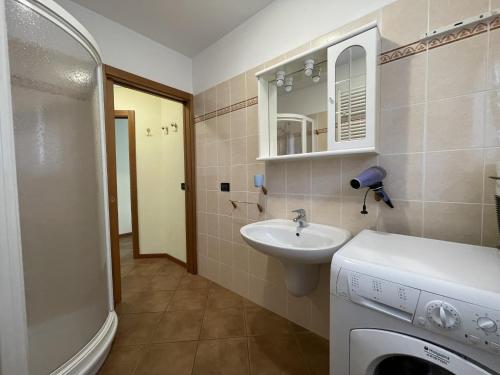 a bathroom with a sink and a washing machine at Trilocale Carisolo 014 in Carisolo