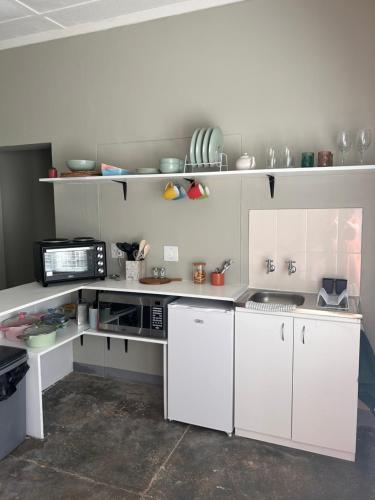 a white kitchen with white cabinets and appliances at Maltahöhe Self Catering in Maltahöhe
