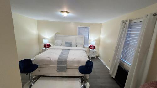 a bedroom with a white bed and two chairs at Casseus J Legacy in Rosedale