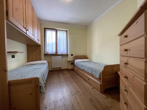 a bedroom with two beds and a window at Trilocale Carisolo 014 in Carisolo