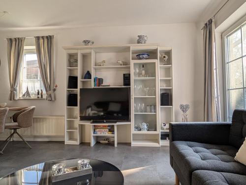a living room with a couch and a tv at Ferienhaus Lükko in Greetsiel