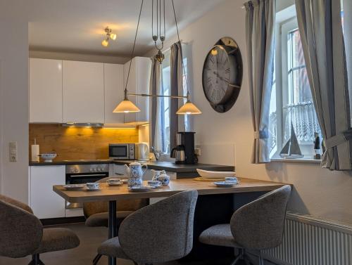 a kitchen with a table and chairs and a clock on the wall at Ferienhaus Lükko in Greetsiel