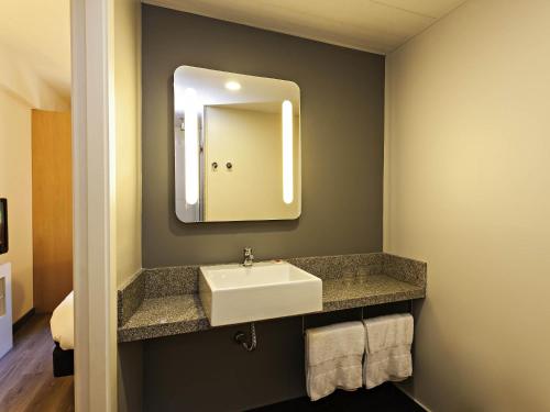 a bathroom with a sink and a mirror at ibis Pilar in Pilar