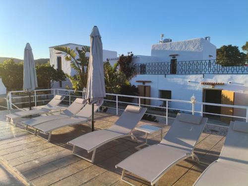a group of chairs and umbrellas on a deck at Can Joan Yern in Sant Joan de Labritja