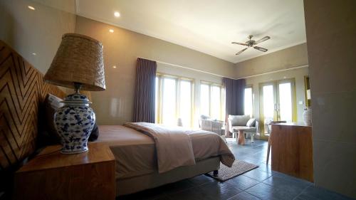 a bedroom with a bed and a lamp on a table at Bayu - Ocean View - Boutique Hotel in Karangasem