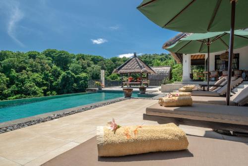 a villa with a swimming pool and a resort at Villa Bayu - exclusive villa with infinity pool, wellness pavilion, panoramic ocean view & full service in Temukus