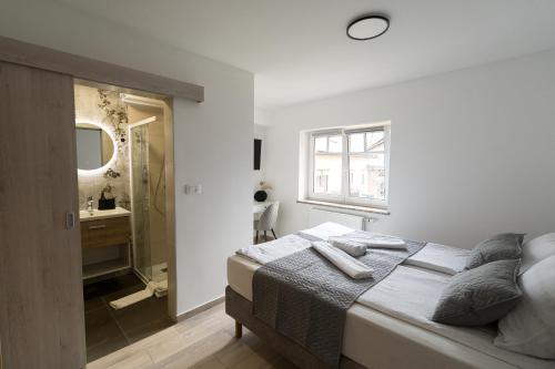 a bedroom with a bed and a bathroom with a sink at Double Room with Breakfast Free Parking and EV ready in Postojna