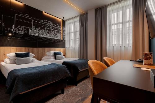 a hotel room with two beds and a desk at Butikowy Hotel M23 Katowice Centrum in Katowice
