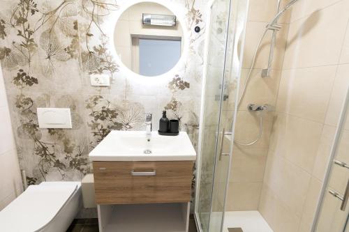 a bathroom with a sink and a shower with a mirror at Double Room with Breakfast Free Parking and EV ready in Postojna