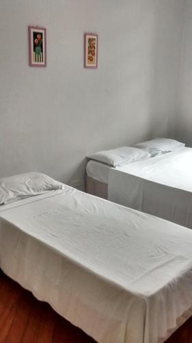 two beds sitting next to each other in a room at Pousada Vila Pitanga in Santos