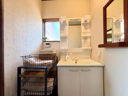 a small kitchen with a sink and a mirror at SSK Mountain Base in Tsumagoi