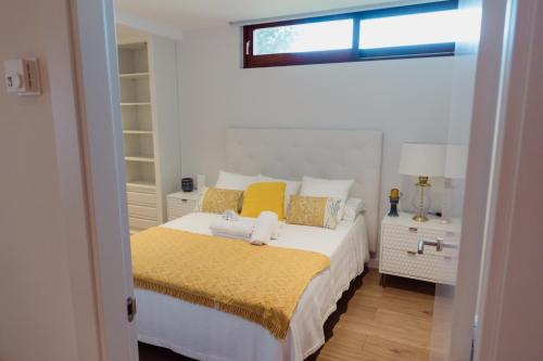 a bedroom with a bed with yellow pillows and a window at Apartamento Saiáns in Oya