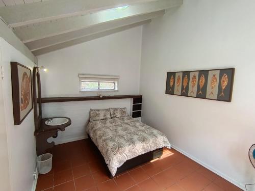 a small bedroom with a bed and a sink at Sandkasteel Self-Catering Accommodation in Vosburg