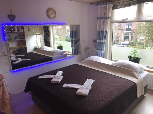 a bedroom with two beds and a large mirror at Guesthouse Czaar Peter in Zaandam