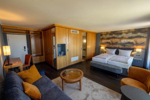 a hotel room with a bed and a couch at Michels Strandhotel Germania in Norderney