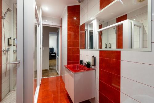 a red and white bathroom with a red sink at Schiller Apartment - Old Town in Sibiu
