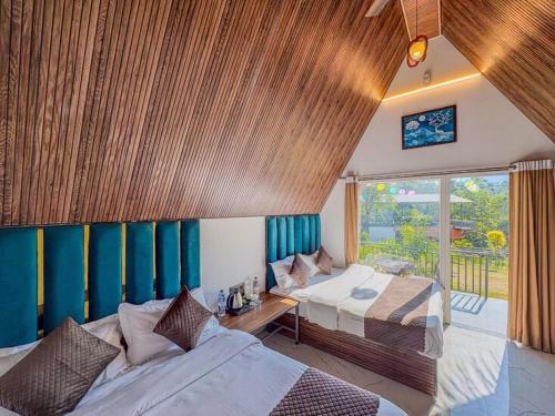 a bedroom with two beds and a large window at The Jungle Walker Resort in Rishīkesh