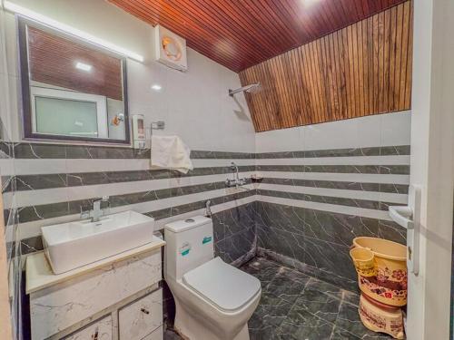 a bathroom with a white toilet and a sink at The Jungle Walker Resort in Rishīkesh