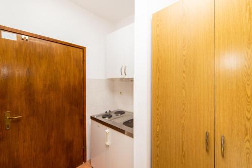 a kitchen with a wooden cabinet and a sink at Apartmani More in Gradac