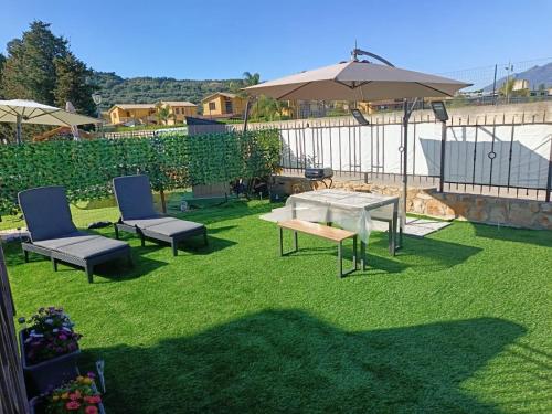 a patio with a table and chairs and an umbrella at Raggio di Sole in Campofelice di Roccella