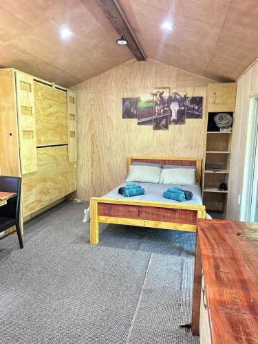 a bedroom with a bed in a room with wooden walls at Secluded Redwood Cabin in Ashley Clinton