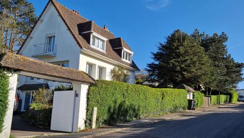 a white house with a white door and a hedge at ST MARTIN PLAGE in Saint-Martin-Plage