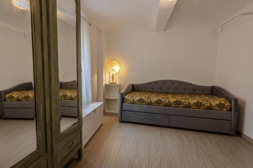 a bedroom with a bed and a mirror in it at Maison Orange - Dimora nelle Langhe in Neive