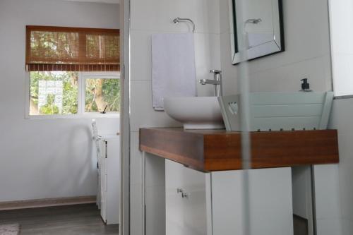a bathroom with a sink and a mirror at Luxury Suites on Santorini in East London