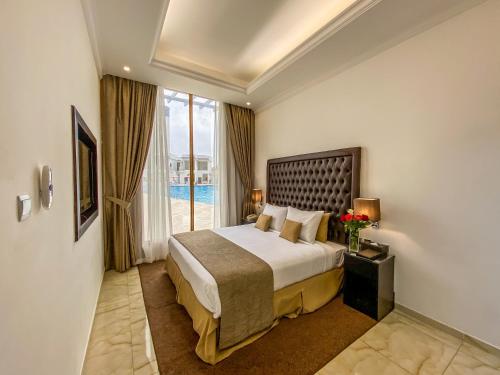 a hotel room with a bed and a large window at Mirage Bab Al Bahr Hotel in Dibba