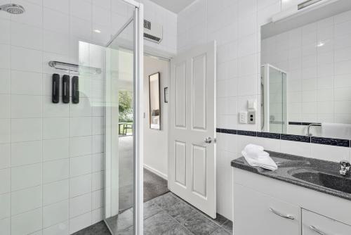 a white bathroom with a sink and a mirror at Lime Tree Lodge in Wanaka