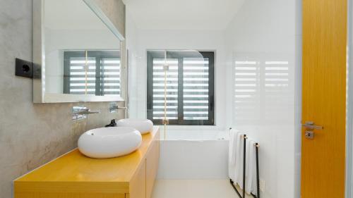 a bathroom with two sinks and a bath tub at Villa Vitoria - by LovelyStay in Funchal