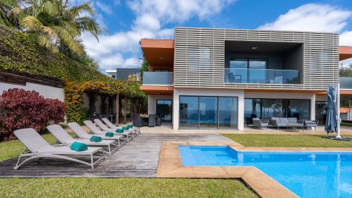 a villa with a swimming pool and lounge chairs at Villa Vitoria - by LovelyStay in Funchal